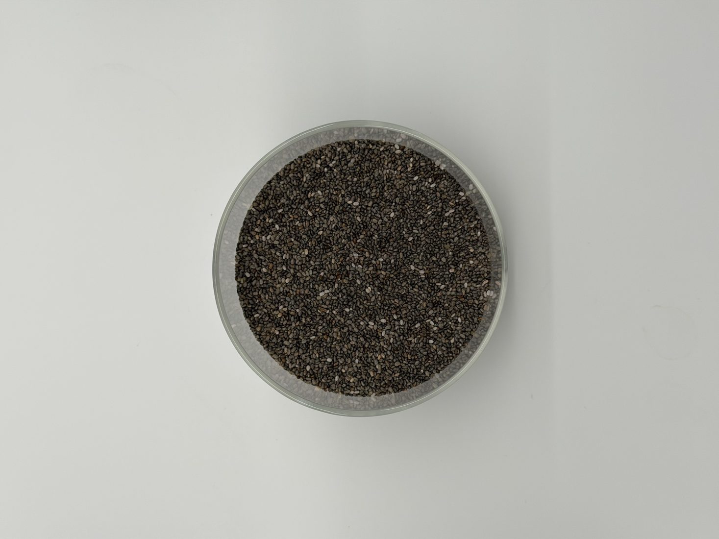 Bowl of chia seeds on a white table